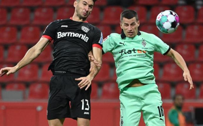 Lucas Alario (l) kämpft mit Mönchengladbachs Verteidiger Stefan Lainer um den Ball. Foto: Ina Fassbender/AFP POOL/dpa