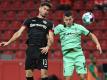 Lucas Alario (l) kämpft mit Mönchengladbachs Verteidiger Stefan Lainer um den Ball. Foto: Ina Fassbender/AFP POOL/dpa