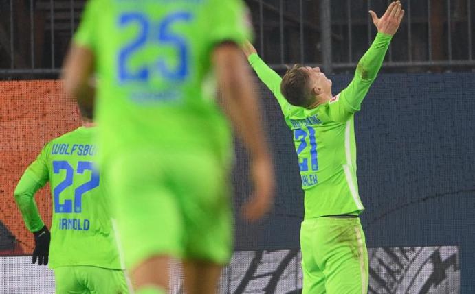 Wolfsburgs Bartosz Bialek jubelt nach seinem Tor zum 5:3. Seine Teamkollegen rennen zu ihm. Foto: Swen Pförtner/dpa