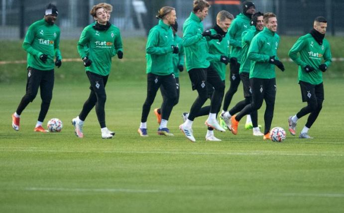 Die Spieler von Borussia Mönchengladbach laufen sich für das Training warm. Foto: Marius Becker/dpa
