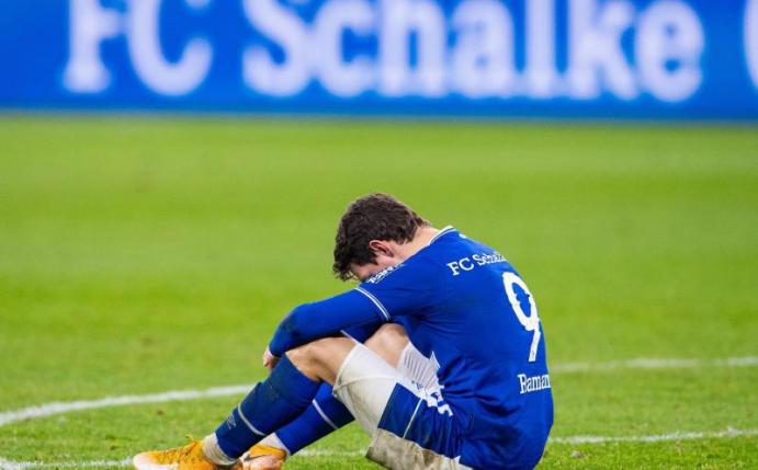 Schalkes Benito Raman sitzt nach dem Abpfiff auf dem Rasen. Foto: Guido Kirchner/dpa