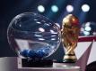 Der FIFA-WM-Pokal steht bei der Auslosung neben den Losen. Foto: Kurt Schorrer/FIFA/dpa