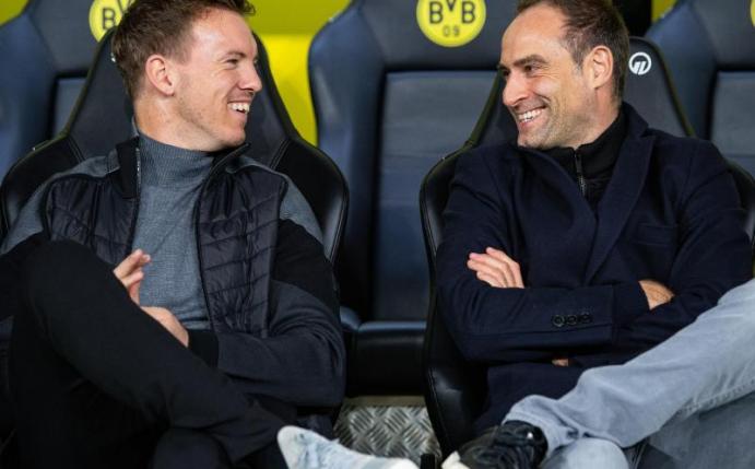 Sitzt laut Vorstandsboss Oliver Mintzlaff (r) auch im nächsten Jahr auf der RB- und nicht auf der BVB-Bank: Trainer Julian Nagelsmann. Foto: Guido Kirchner/dpa