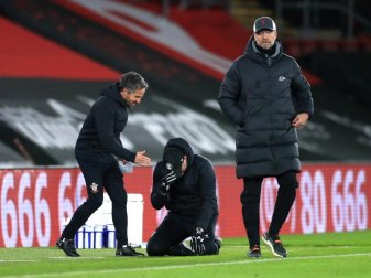 Während Southamptons Trainer Ralph Hasenhüttl (M) auf die Knie fällt zeigt sich Liverpools Trainer Jürgen Klopp (r) frustriert. Foto: Adam Davy/PA Wire/dpa