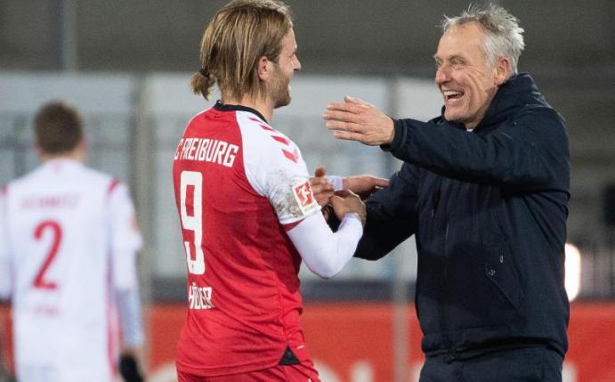 Freiburgs Trainer Christian Streich (r) freut sich nach dem Spiel mit Torschütze Lucas Höler. Foto: Sebastian Gollnow/dpa