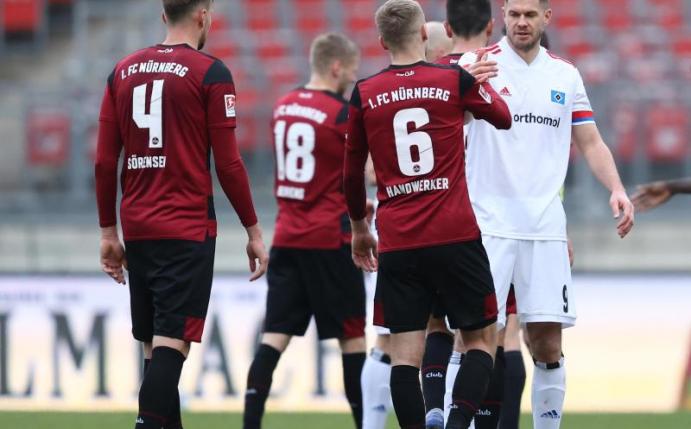 Simon Terodde vom HSV (r) nach dem Spiel beim Handschlag mit Tim Handwerker (6) vom FC Nürnberg. Foto: Daniel Karmann/dpa