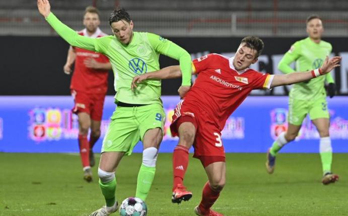 Robin Knoche (r) von Union Berlin im Duell um den Ball mit Wolfsburgs Wout Weghorst. Foto: John Macdougall/AFP-Pool/dpa