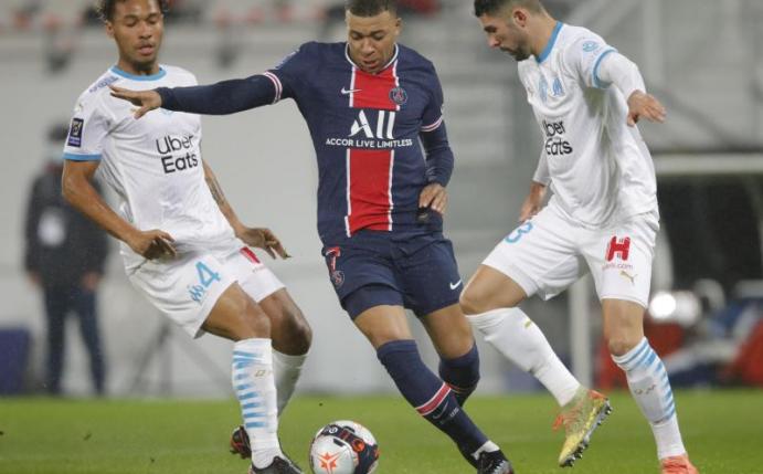 Kylian Mbappé (M.) setzt sich gegen zwei OM-Profis durch. Foto: Christophe Ena/AP/dpa
