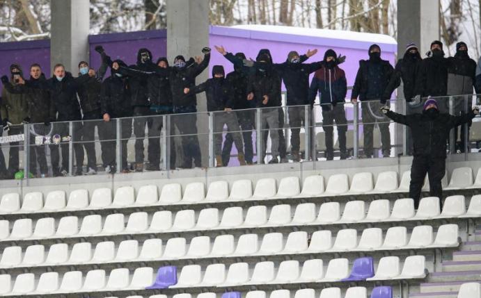 Zuschauer stehen beim Spiel des FC Erzgebirge Aue gegen Fortuna Düsseldorf auf der Tribüne. Foto: Robert Michael/dpa-Zentralbild/dpa