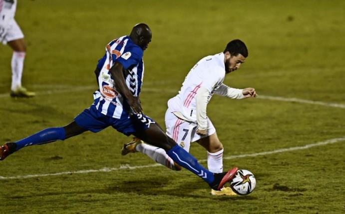 Ali Diakite (l) von CD Alcoyano stoppt Madrids Eden Hazard mit einer beherzten Grätsche. Foto: Jose Breton/AP/dpa