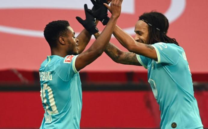 Torschütze Ridle Baku (l) ließ sich nach seinem Tor von Mitspieler Kevin Mbabu feiern. Foto: Ina Fassbender/AFP/Pool/dpa