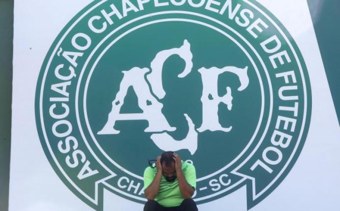 Ein Anhänger von Chapecoense trauert 2016 während einer Mahnwache vor dem Logo des Vereins um die Opfer des Flugzeugunglücks. Foto: Sebastiao Moreira/EFE/dpa