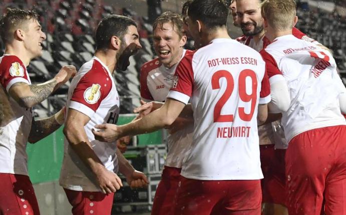 Die Spieler von Rot-Weiss Essen feiern Oguzhan Kefkir (2.v.l) nach seinem Tor gegen Leverkusen. Foto: Martin Meissner/AP POOL/dpa