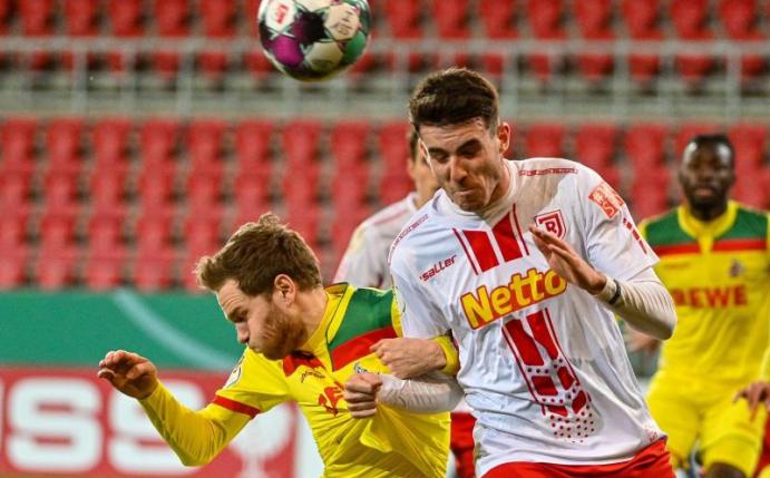 Benno Schmitz vom 1. FC Köln (l) und Kaan Caliskaner von Jahn Regensburg beim Kopfballduell. Foto: Armin Weigel/dpa