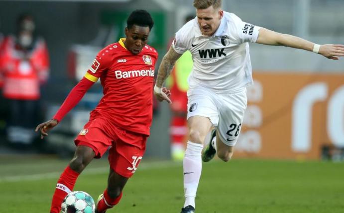 Leverkusens Jeremie Frimpong (l) und Augsburgs Andre Hahn im Zweikampf um den Ball. Foto: Tom Weller/dpa