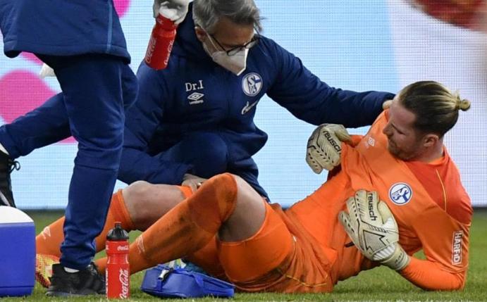 Schalkes Torhüter Ralf Fährmann wird nach seiner Verletzung in der Veltins Arena betreut. Foto: Martin Meissner/Pool AP/dpa