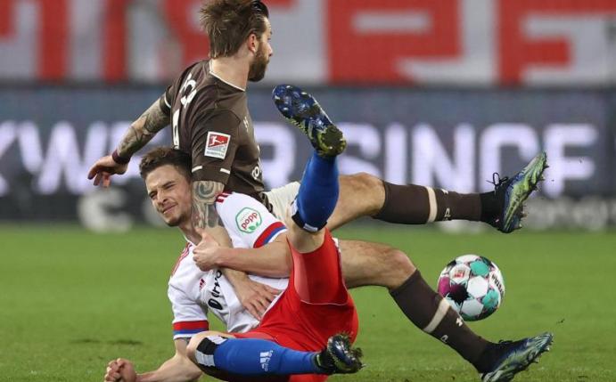 Moritz Heyer (l) vom HSV und Guido Burgstaller vom FC St. Pauli kämpfen um den Ball. Foto: Christian Charisius/dpa-Pool/dpa