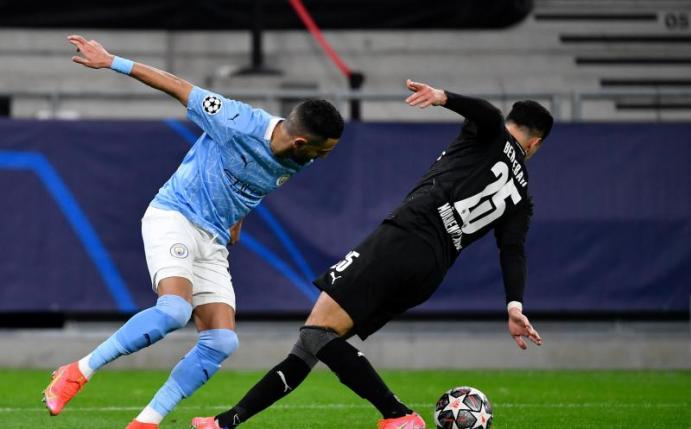Manchester Citys Riyad Mahrez und Gladbachs Ramy Bensebaini (r) kämpfen um den Ball. Foto: Marton Monus/dpa