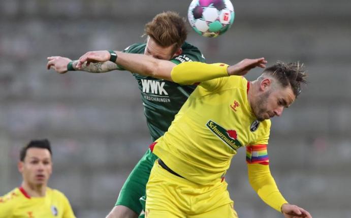 Gelb statt rot: Der Freiburgs (rechts Christian Günter) trat gegen den FC Augsburg in den Auswärtsfarben an. Foto: Tom Weller/dpa