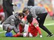 Betreuer kümmern sich um den verletzten Mainzer Abwehrspieler Danny da Costa. Foto: Torsten Silz/dpa