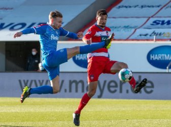 Heidenheims Tim Kleindienst (r) und Kiels Jannik Dehm kämpfen um den Ball. Foto: Stefan Puchner/dpa