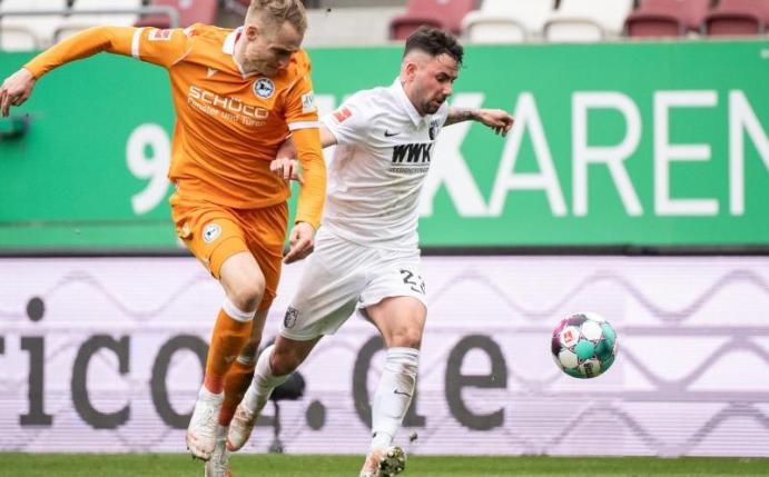 Bielefelds Amos Pieper (l) und Augsburgs Marco Richter im Zweikampf um den Ball. Foto: Matthias Balk/dpa