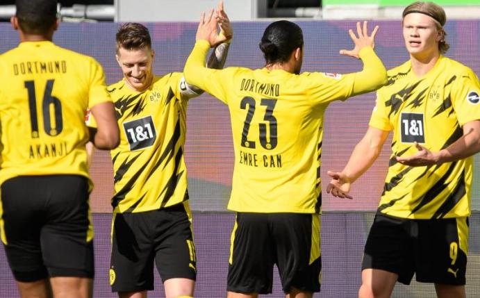 Dortmunds Matchwinner Erling Haaland (r) wird von seinen BVB-Teamkollegen in Wolfsburg gefeiert. Foto: Swen Pförtner/dpa
