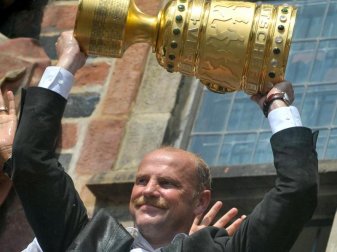 Der damalige Werder-Trainer Thomas Schaaf feiert auf dem Balkon des Bremer Rathhauses mit dem DFB-Pokal. Foto: picture alliance / dpa