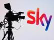 Eine Fernsehkamera und ein Sky-Logo. Foto: Tobias Hase/dpa/Illustration