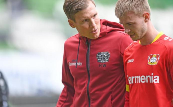 Leverkusens Trainer Hannes Wolf (l) spricht mit Daley Sinkgraven auf dem Weg in die Halbzeit. Foto: Carmen Jaspersen/dpa