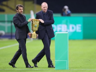 Karl-Heinz Riedle (l) und Perry Bräutigam tragen den DFB-Pokal auf das Feld. Foto: Jan Woitas/dpa-Pool/dpa Karl-Heinz Riedle (l) und Perry Bräutigam tragen den DFB-Pokal auf das Feld. Foto: Jan Woitas/dpa-Pool/dpa