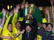 BVB-Coach Edin Terzic streckt den DFB-Pokal in den Berliner Nachthimmel. Foto: Martin Rose/Getty-Pool/dpa