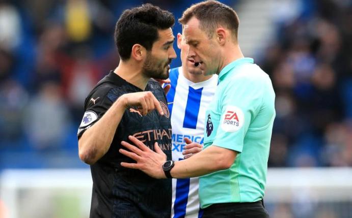 Ilkay Gündogan (l) von Manchester City im Gespräch mit Schiedsrichter Stuart Attwell. Foto: Gareth Fuller/PA Wire/dpa