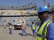 Bauarbeiter arbeiten am Lusail-Stadion, einem der Stadien der WM 2022. Foto: Hassan Ammar/AP/dpa