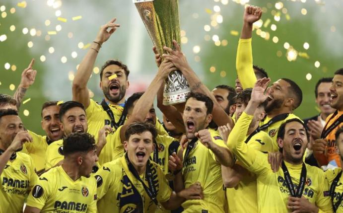 Villarreals Spieler heben den Pokal und feiern ihren Sieg. Foto: Maja Hitij/Pool Getty/AP/dpa