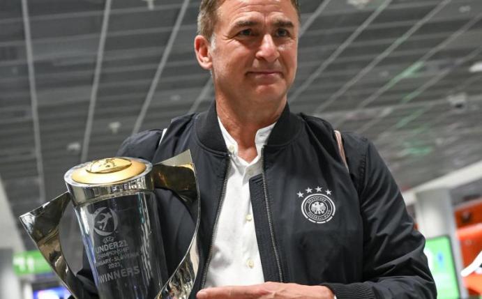 Bundestrainer Stefan Kuntz mit dem Pokal für den Gewinn der U21-Europameisterschaft. Foto: Sebastian Gollnow/dpa