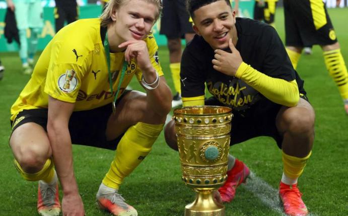 Jadon Sancho posiert mit BVB-Stürmer Erling Haaland (l) und dem DFB-Pokal. Foto: Martin Rose/Getty-Pool/dpa