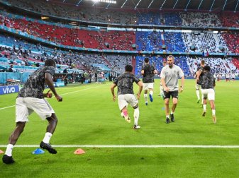 Die deutschen Spieler wärmen sich vor dem Spiel gegen Frankreich auf - drei aus dem Kader müssen aber auf der Tribüne sitzen. Foto: Federico Gambarini/dpa