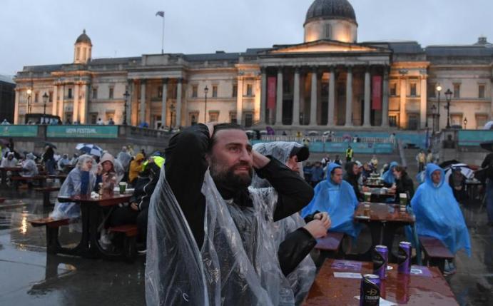 Englische Fußballfans reagieren am Trafalgar Square, während sie das Spiel verfolgen. Foto: Alberto Pezzali/AP/dpa