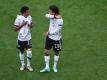 Deutschlands Serge Gnabry und Leroy Sané (r) unterhalten sich nach einer Partie auf dem Platz. Foto: Federico Gambarini/dpa