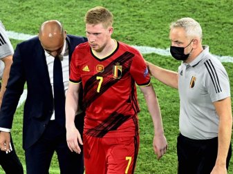 Belgiens Cheftrainer Roberto Martinez (l-r) und Physiotherapeut begleiten Kevin De Bruyne vom Spielfeld. Foto: Dirk Waem/BELGA/dpa