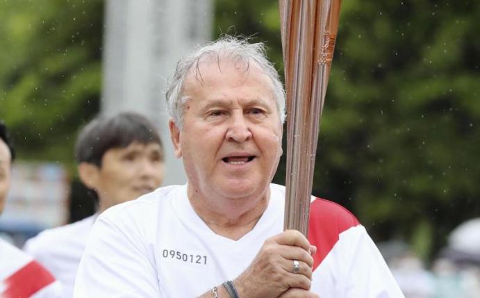 Der frühere brasilianische Fußball-Weltstar Zico trägt die olympische Fackel in der Nähe des Kashima-Stadions in Japan. Foto: -/kyodo/dpa