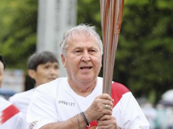 Der frühere brasilianische Fußball-Weltstar Zico trägt die olympische Fackel in der Nähe des Kashima-Stadions in Japan. Foto: -/kyodo/dpa