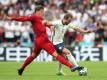 Dänemarks Jannik Vestergaard (l) und Englands Harry Kane kämpfen um den Ball - im Hintergrund eine chinesische Bandenwerbung. Foto: Nick Potts/PA Wire/dpa