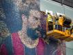 Arbeiter entfernen das Messi-Porträt an der Fassade vom Camp Nou, wo 30.000 Fans zum Heimspiel des FC Barcelona kommen dürfen. Foto: Matthias Oesterle/ZUMA Press Wire/dpa