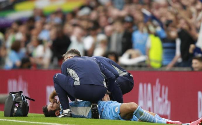 Ilkay Gündogan wird während des Spiels medizinisch versorgt. Foto: Ian Walton/AP/dpa