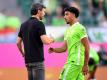 Wolfsburgs Trainer Mark van Bommel klatscht nach der Pokalpartie gegen Preußen Münster mit Omar Marmoush ab. Foto: Swen Pförtner/dpa