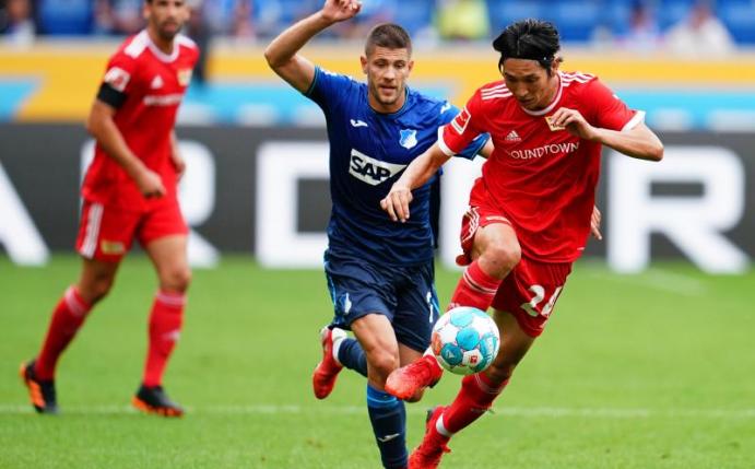 Unions Genki Haraguchi (r) im Laufduell mit dem Hoffenheimer Andrej Kramaric. Foto: Uwe Anspach/dpa
