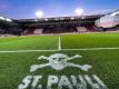 Das Logo von St.Pauli ist an der Mittellinie vor den Trainerbänken auf den Rasen des Millerntorstadions gesprüht. Foto: Christian Charisius/dpa