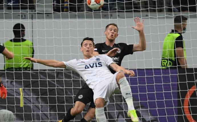 Frankfurts Erik Durm (r) und Istanbuls Mesut Özil kämpfen um den Ball. Foto: Arne Dedert/dpa